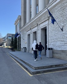 Hochschulgebäude in Tallinn mit Säulenportikus, estnischer Flagge und Europaflagge